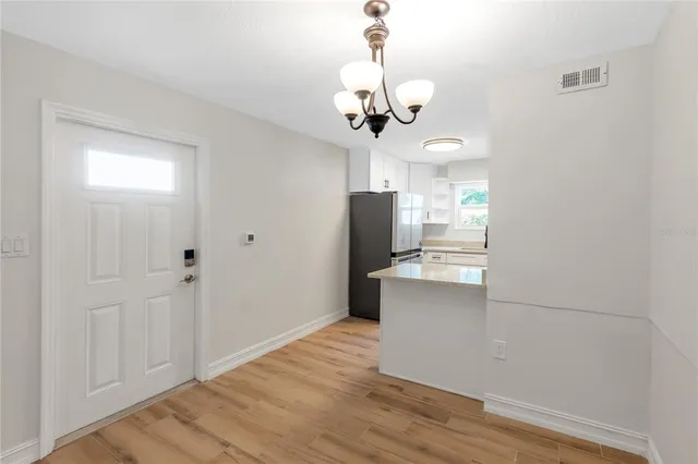 an empty room with wooden floor and ceiling fan