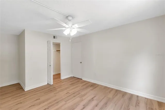 a view of a room with wooden floor and a ceiling fan