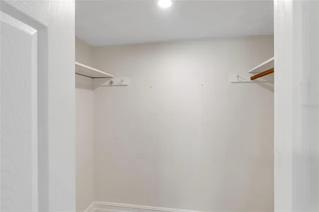 a view of a room with wooden floor and a ceiling fan