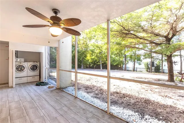 a view of a brick house with large windows and a small yard