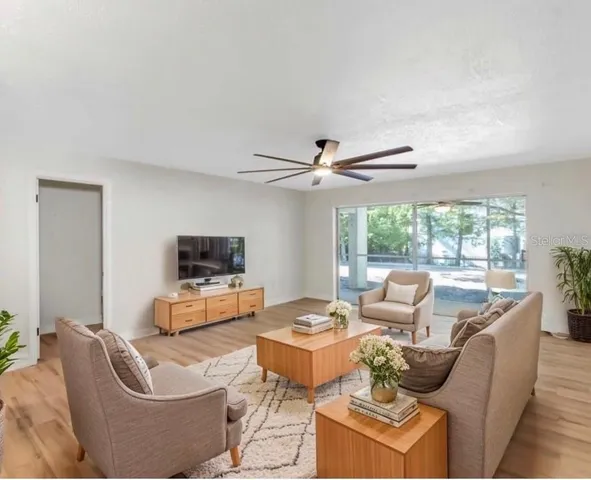a view of empty room with wooden floor and fan