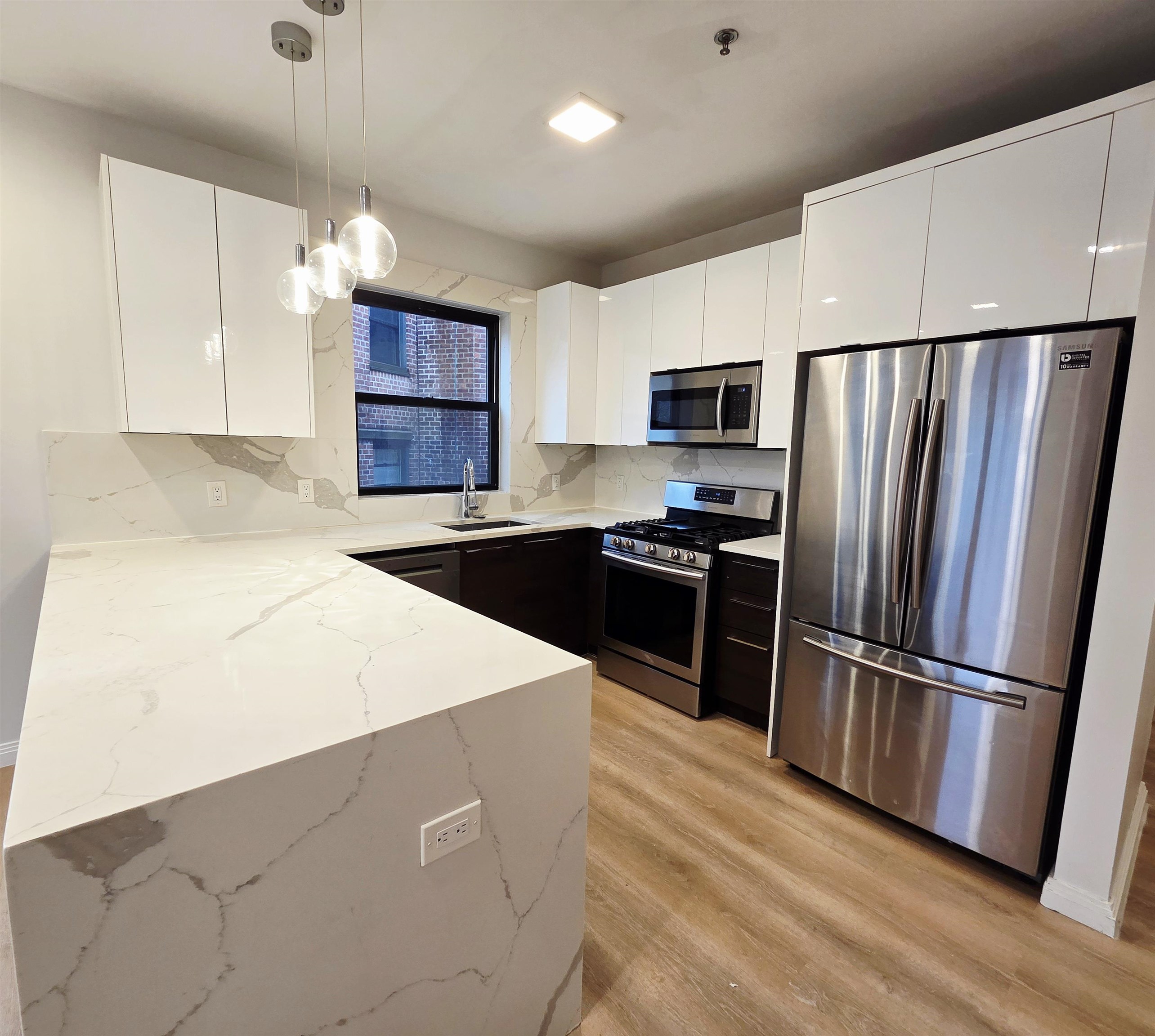 6809 Palisade Avenue, Unit 201 Guttenberg, NJ 07093 - Photo 3 of 11 a kitchen with stainless steel appliances a refrigerator sink and microwave