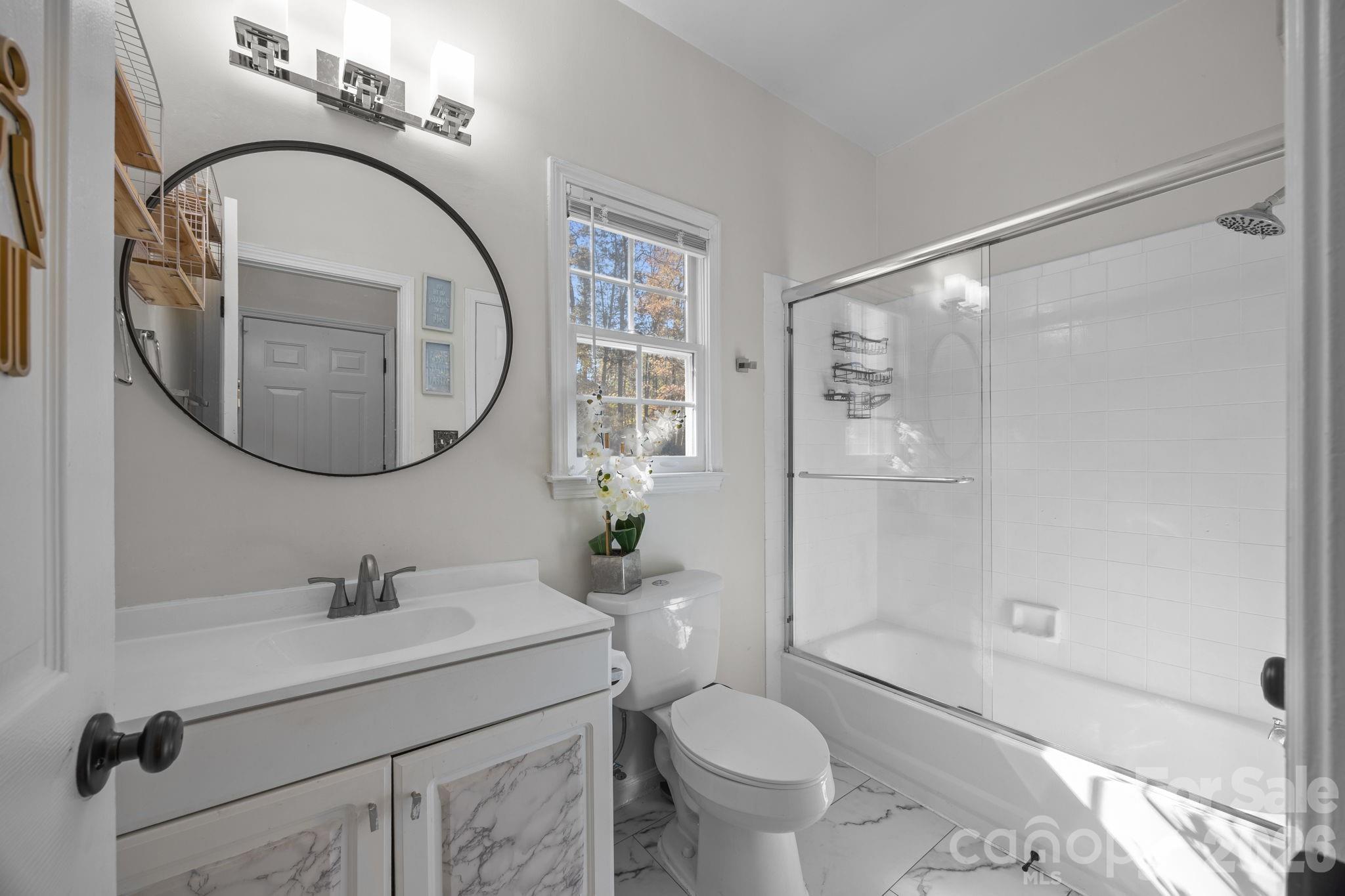 7708 Harrington Woods Road Charlotte, NC 28269 - Photo 24 of 35 a bathroom with a sink a toilet and a mirror