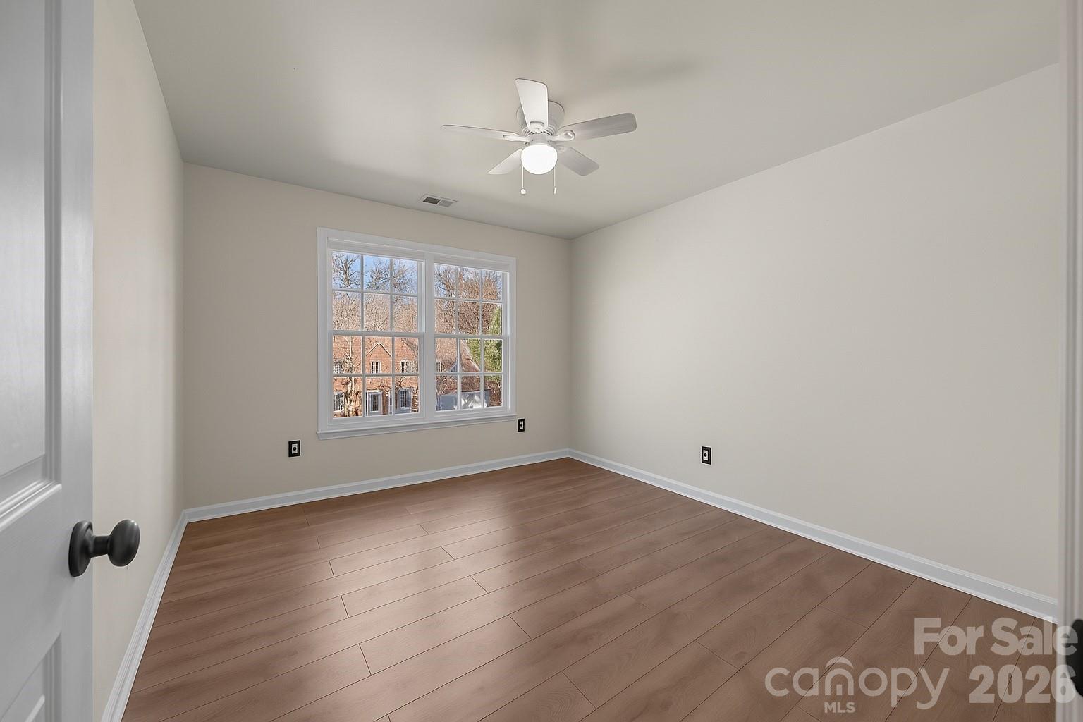 7708 Harrington Woods Road Charlotte, NC 28269 - Photo 28 of 35 an empty room with wooden floor and windows