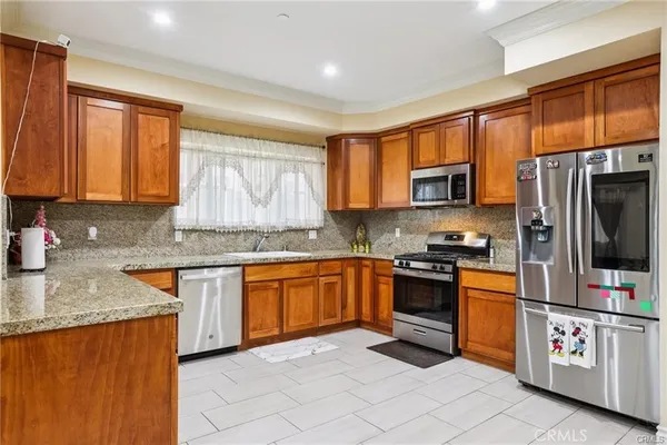 a kitchen with stainless steel appliances granite countertop a stove sink microwave and refrigerator