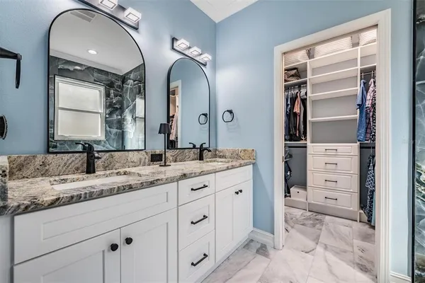a bathroom with a granite countertop sink and a mirror