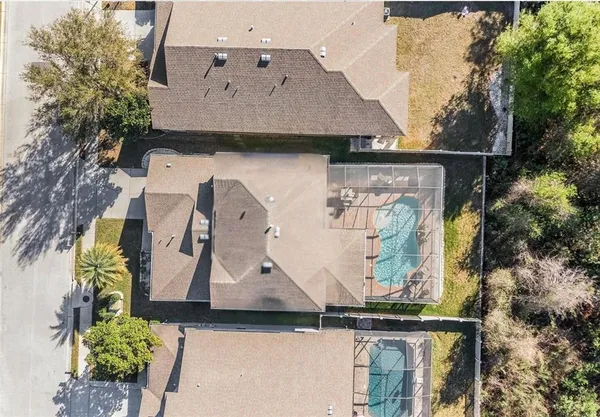 an aerial view of a house with a yard and large trees