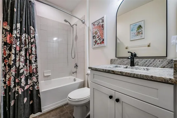 a bathroom with a granite countertop sink a toilet and a bathtub