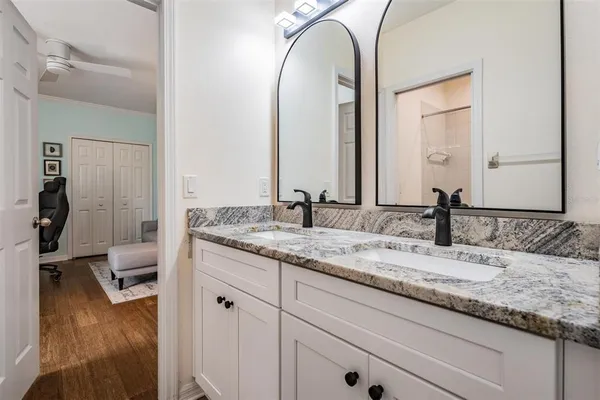 a bathroom with a granite countertop sink and a mirror