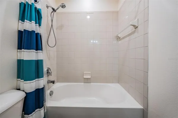 a bathroom with a tub a toilet and a shower