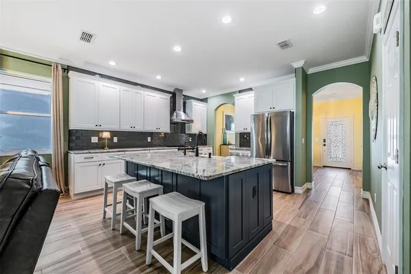 a kitchen with granite countertop kitchen island wooden floors center island and stainless steel appliances