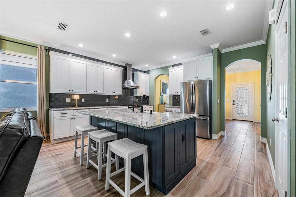 12902 Tikal Way Trinity, FL 34655 - Photo 9 of 43 a kitchen with granite countertop kitchen island wooden floors center island and stainless steel appliances