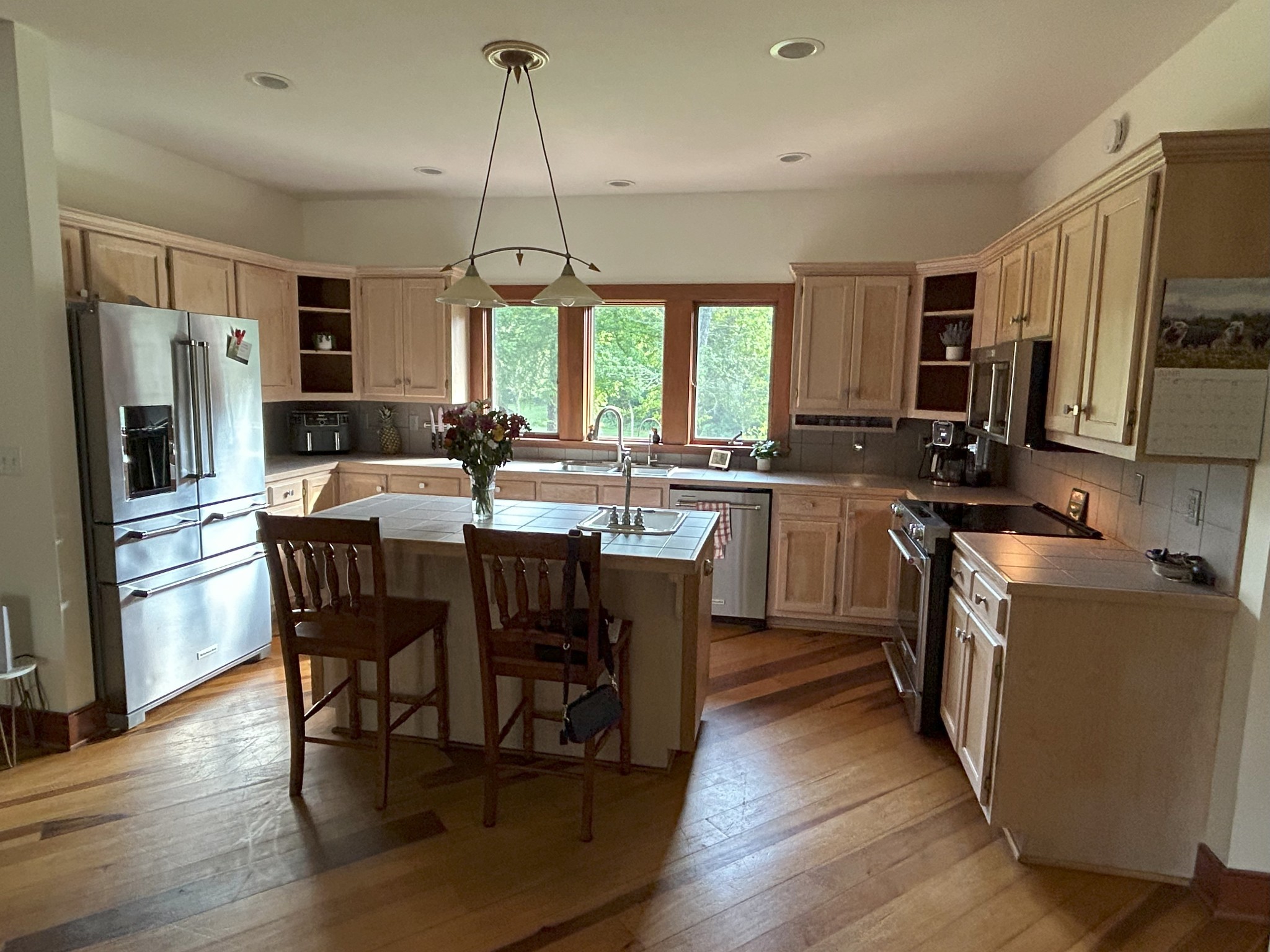 6960 Millersburg Road Christiana, TN 37037 - Photo 8 of 68 a kitchen with stainless steel appliances a dining table chairs stove refrigerator and microwave