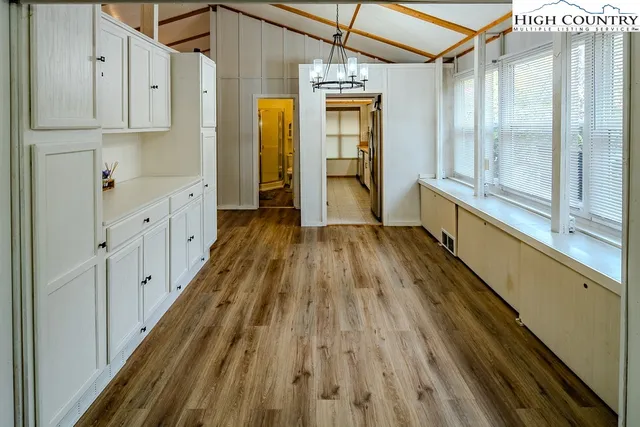 a open kitchen with stainless steel appliances granite countertop a stove a sink dishwasher and a refrigerator with wooden floor