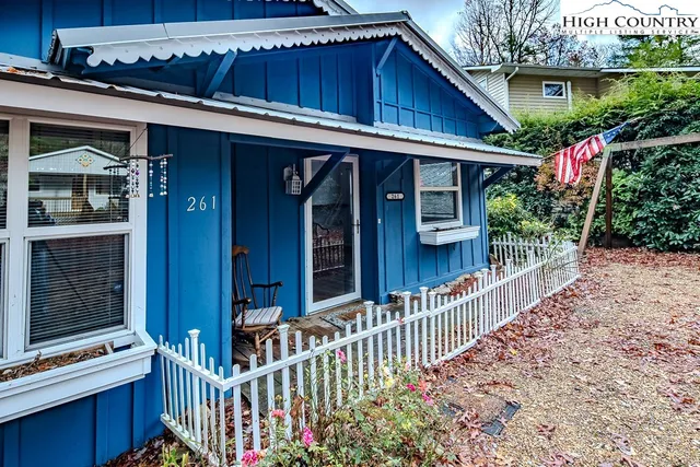 a view of a house with a small yard and wooden fence