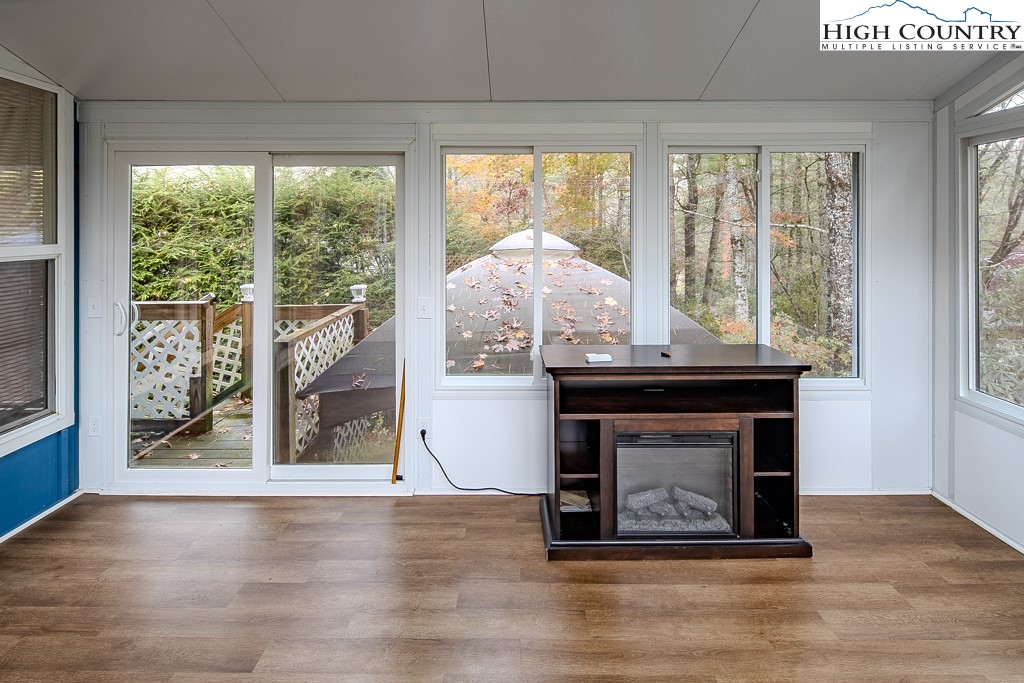 261 Black Pine Road Newland, NC 28657 - Photo 34 of 41 a living room with a fireplace and a floor to ceiling window
