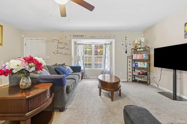 a living room with furniture a flat screen tv and a window