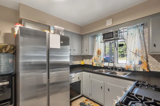 a kitchen with stainless steel appliances a sink and a refrigerator