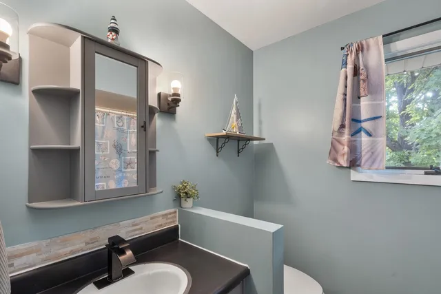 a bathroom with a toilet sink and mirror