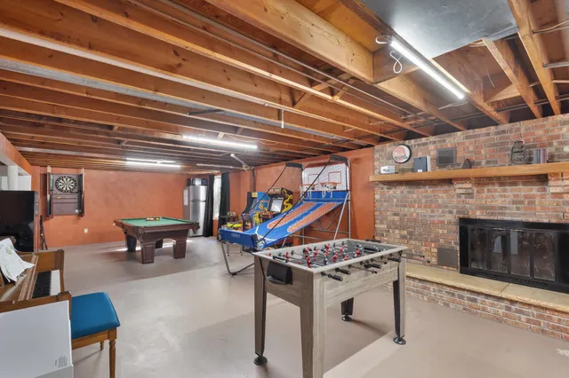 a living room with stainless steel appliances granite countertop a stove a fireplace and a dining table with the kitchen view