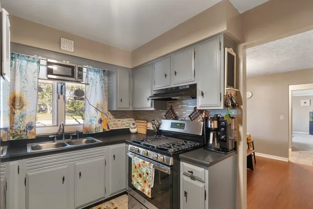 a kitchen with stainless steel appliances a sink a stove and a window