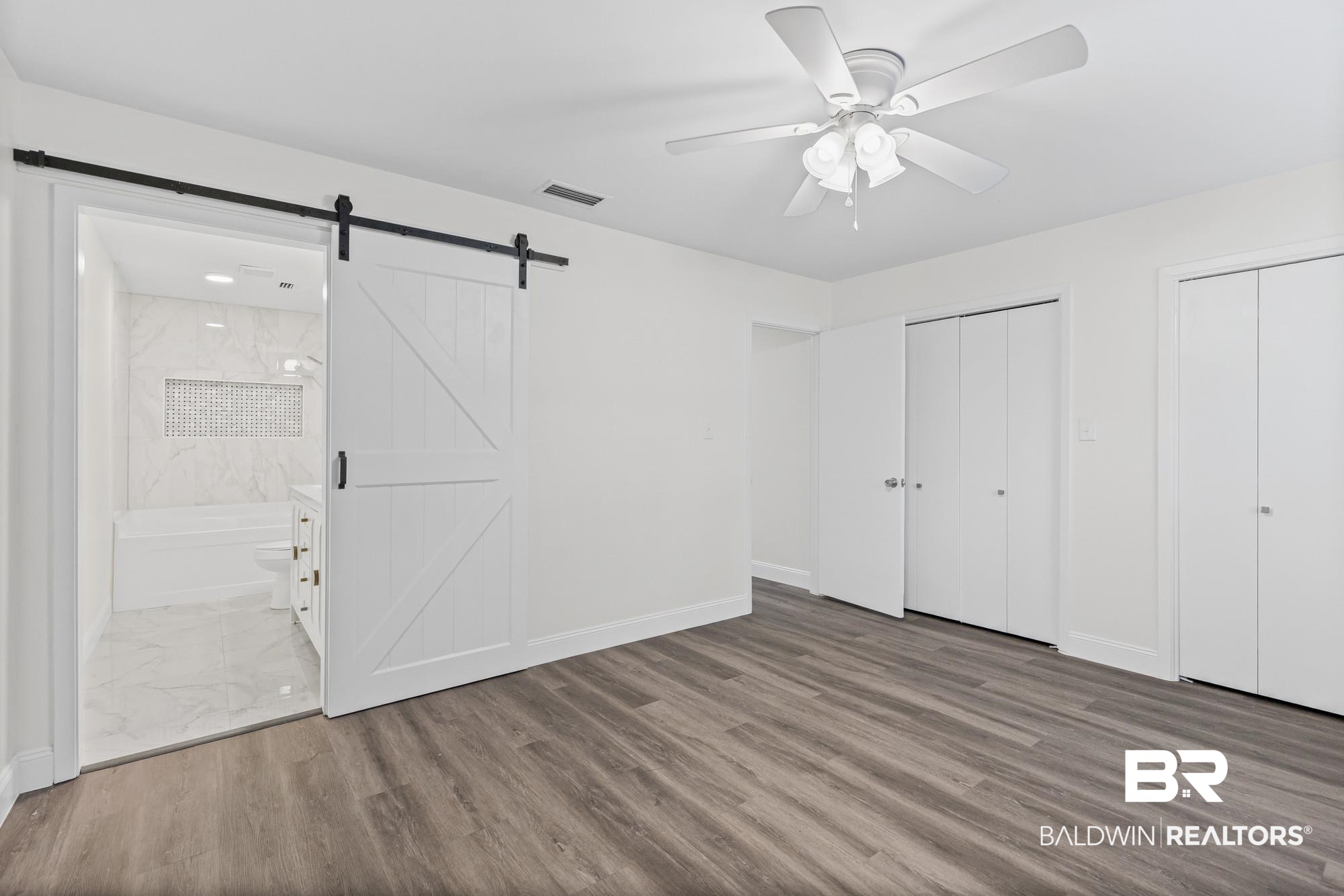 3041 Pretty Branch Drive East Mobile, AL 36618 - Photo 13 of 20 Unfurnished bedroom featuring multiple closets, wood finished floors, ceiling fan, and ensuite bath