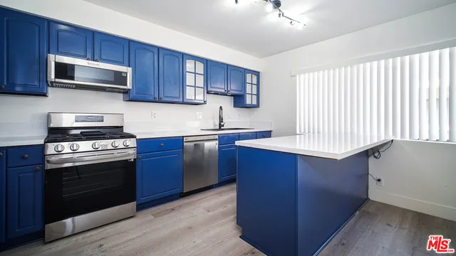 a kitchen with stainless steel appliances granite countertop wooden cabinets a stove top oven a sink and dishwasher