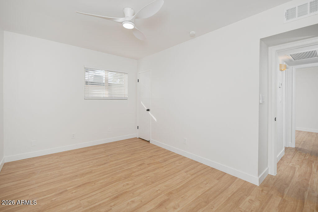 720 South Dobson Road, Unit 85 Mesa, AZ 85202 - Photo 6 of 16 an empty room with wooden floor and ceiling fan