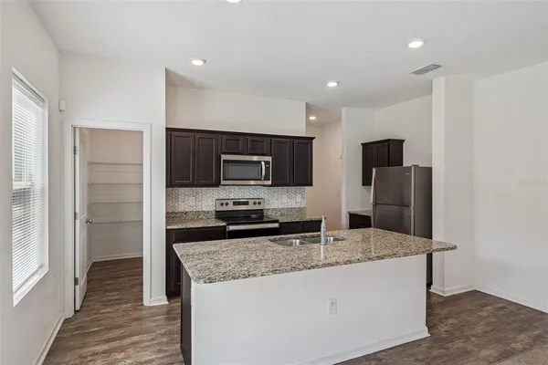 a kitchen with stainless steel appliances granite countertop a sink and a refrigerator