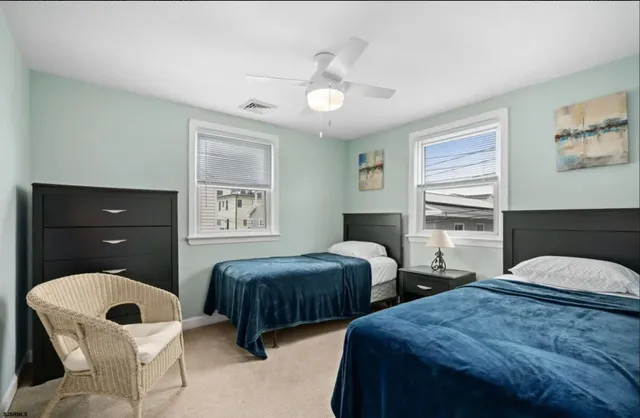 a bedroom with two beds and a chandelier