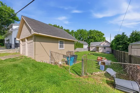a view of backyard with table and chairs plants and wooden fence