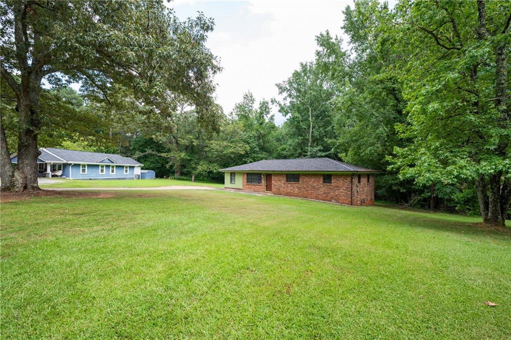 3890 Jailette Road Southwest Atlanta, GA 30349 - Photo 1 of 1 a view of a house with a yard and large trees
