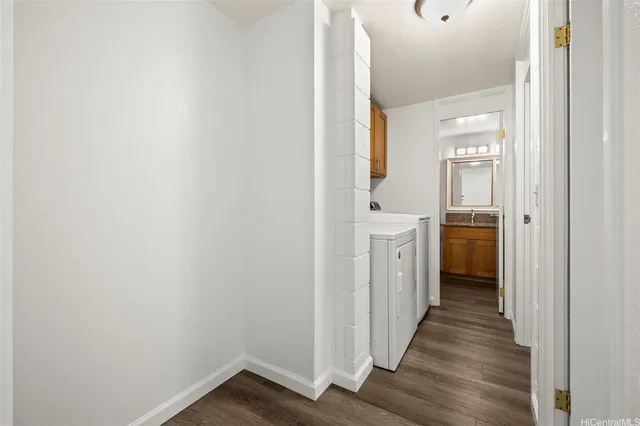 a view of a hallway with wooden floor and a bathroom