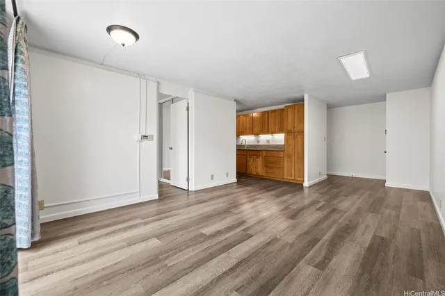 a view of empty room with wooden floor and window