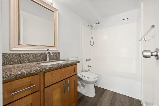 a bathroom with a granite countertop sink toilet and shower