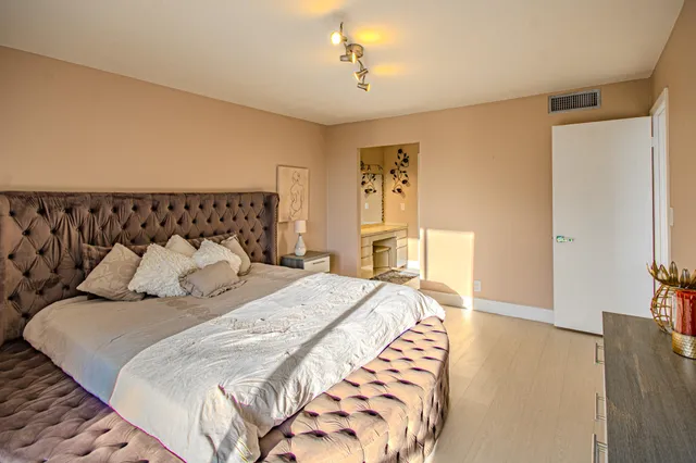 a bedroom with a large bed and a chandelier