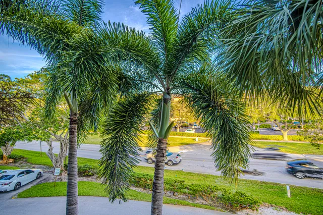 a front view of multi story residential apartment building with yard and green space