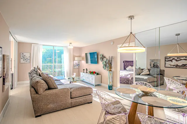 a dining room with wooden floor a chandelier a wooden table and chairs