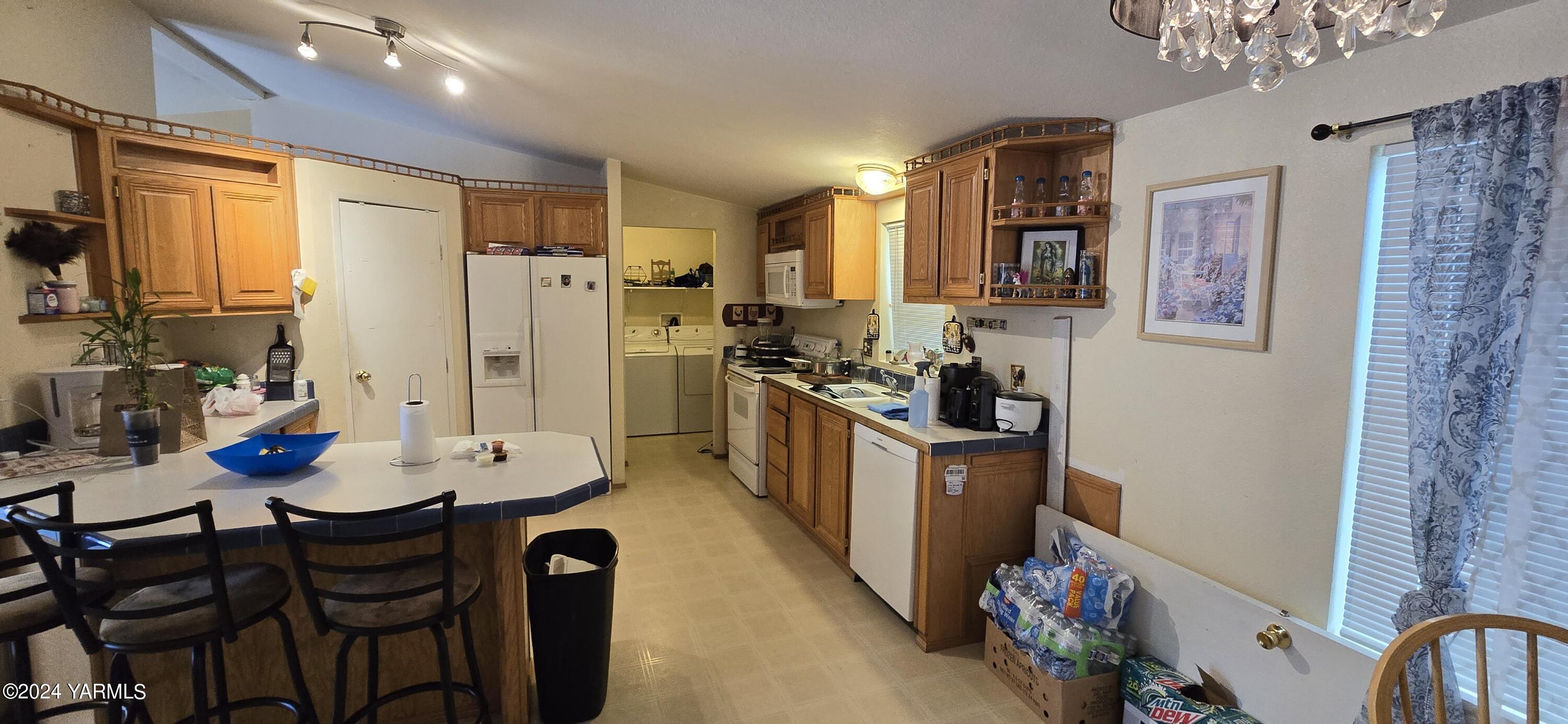 2802 Beaudry Road, Unit 44 Yakima, WA 98901 - Photo 4 of 18 a kitchen with stainless steel appliances kitchen island granite countertop a refrigerator a stove a sink dishwasher and dining table with wooden floor
