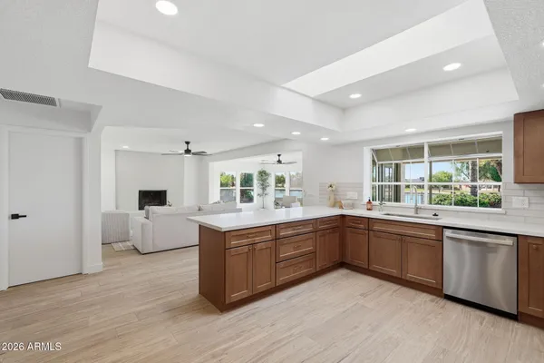 a large kitchen with kitchen island a large counter top space and stainless steel appliances