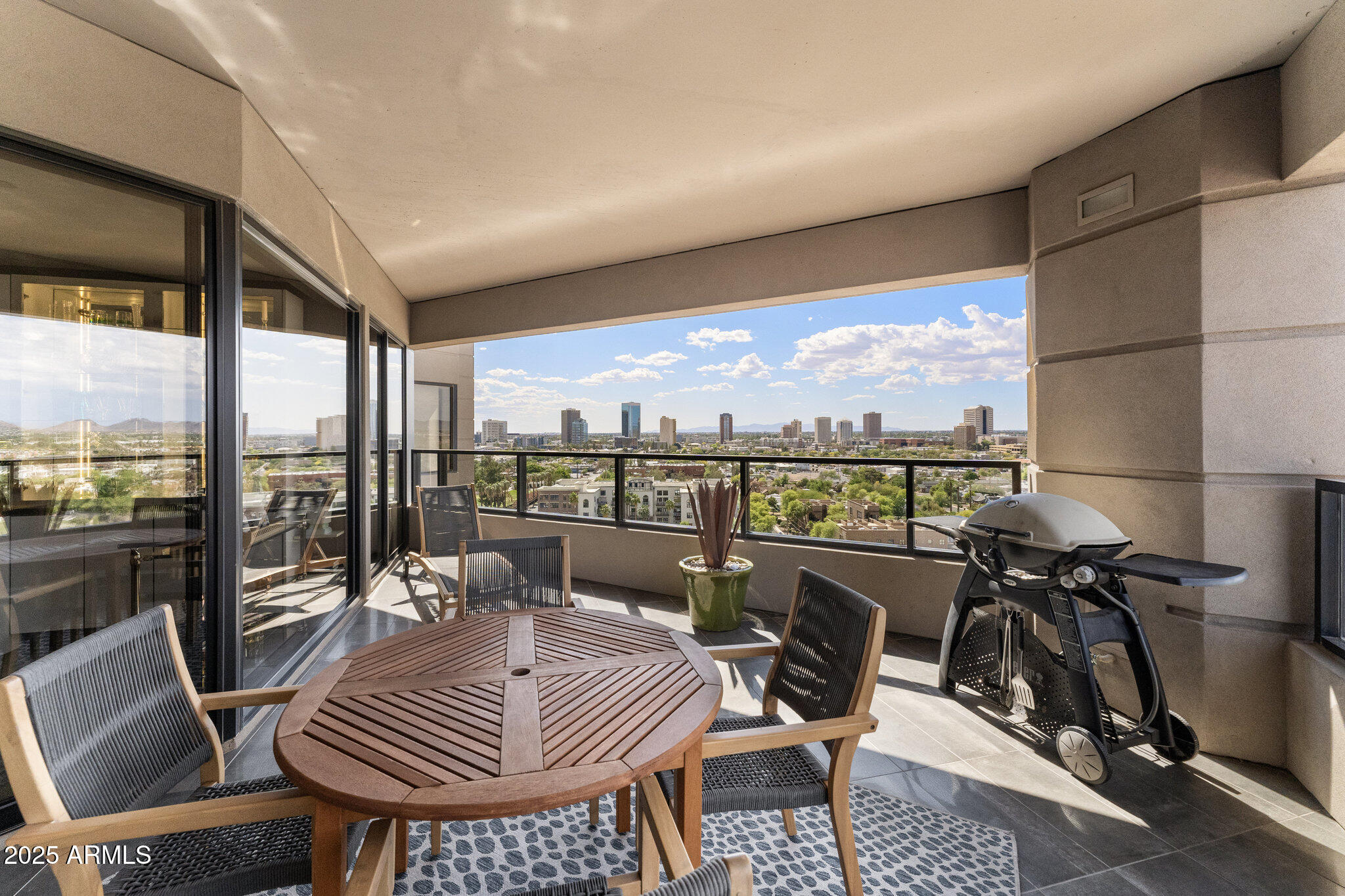 1040 East Osborn Road, Unit 1103 Phoenix, AZ 85014 - Photo 11 of 49 a balcony view with a couch and wooden floor