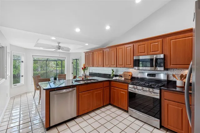 a kitchen with stainless steel appliances granite countertop a stove sink and cabinets