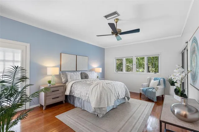 a bedroom with a large bed a potted plant and a window