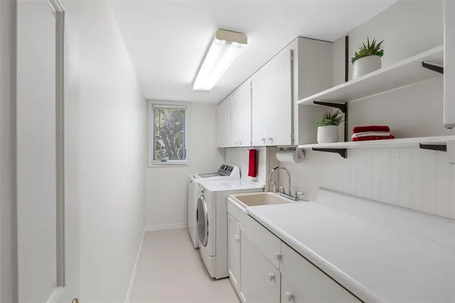 a utility room with cabinets washer and dryer