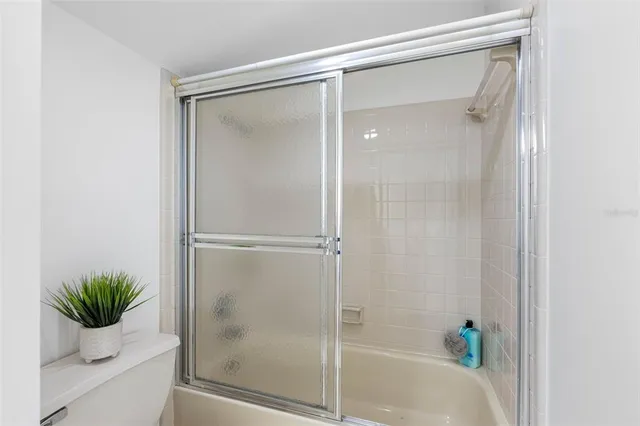 a bathroom with a glass shower door and a window