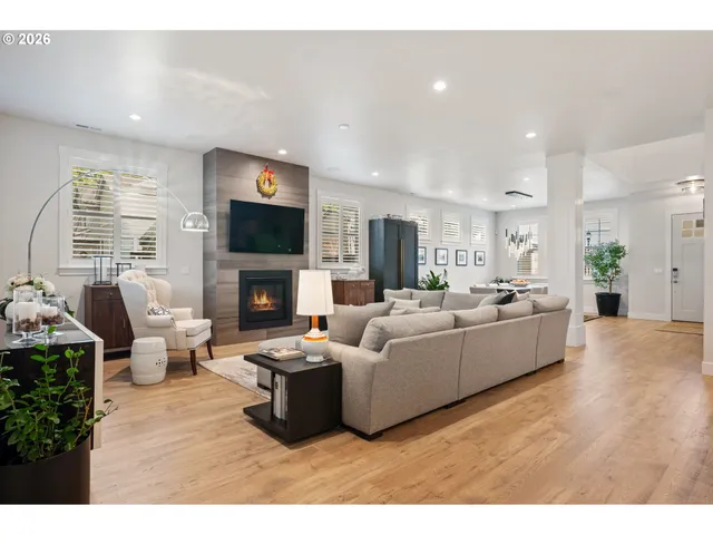 a living room with furniture kitchen and a wooden floor
