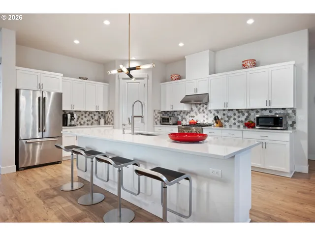 a large kitchen with stainless steel appliances lots of counter space and wooden floor