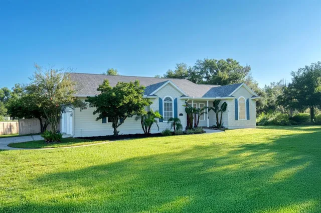 a front view of house with yard and trees in the background