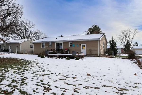 a front view of a house with a yard covered in snow