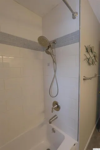 a bathroom with a bath tub with a shower
